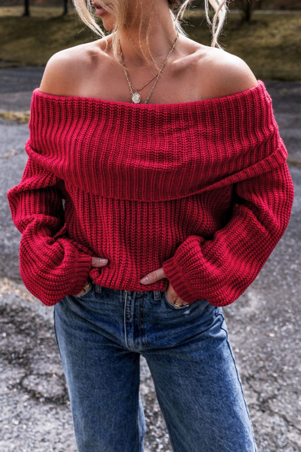 Sleek off-shoulder sweater in deep red acrylic knit with wide sleeves and a ribbed texture.