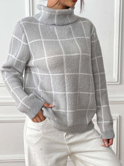 Gray grid-patterned turtleneck knit pullover sweater with long sleeves.