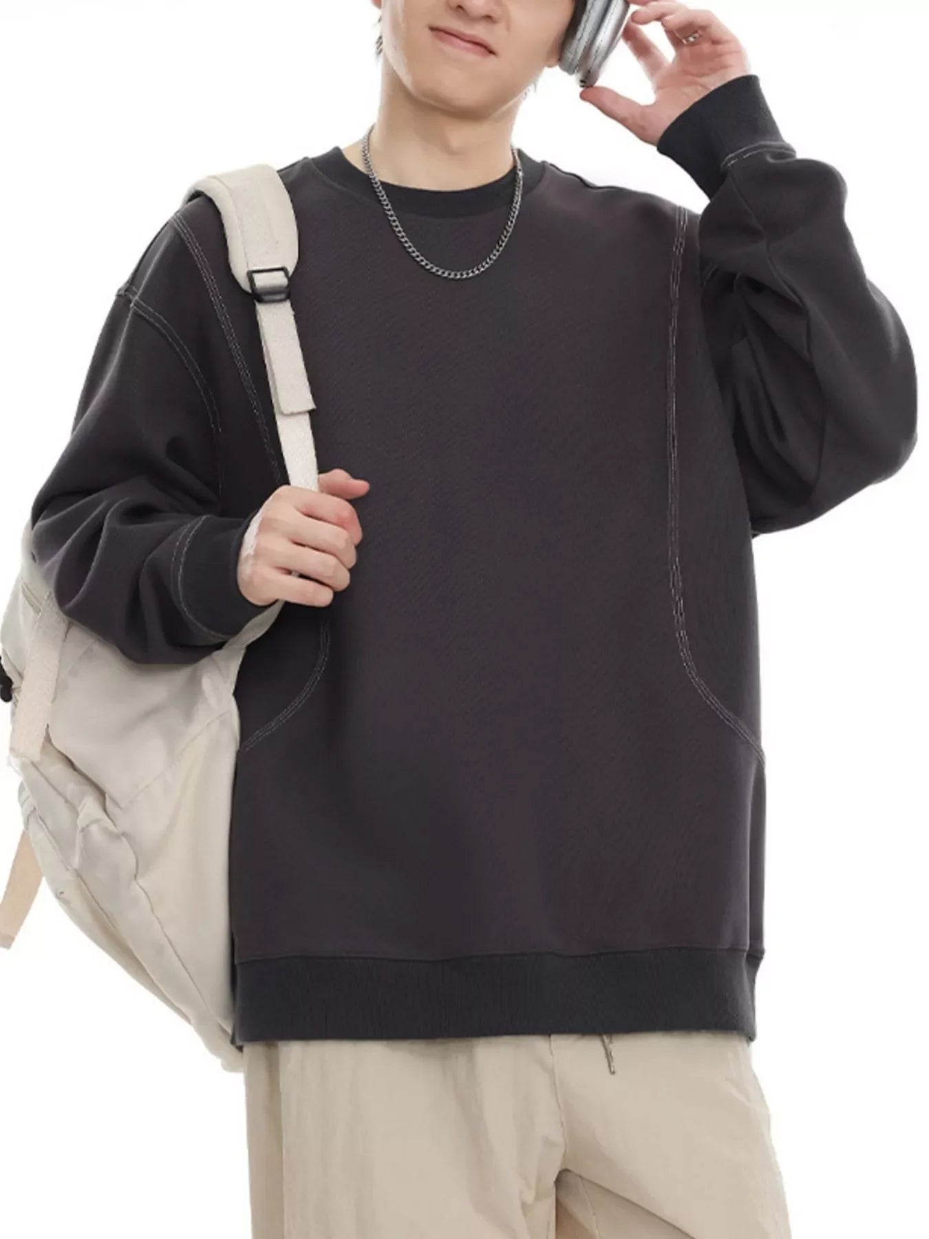 Oversized dark gray long-sleeve sweatshirt with contrast stitching and crew neck.