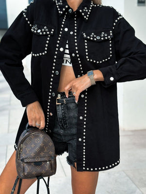 Black studded denim shirtdress with a belted waist, worn with denim shorts.
