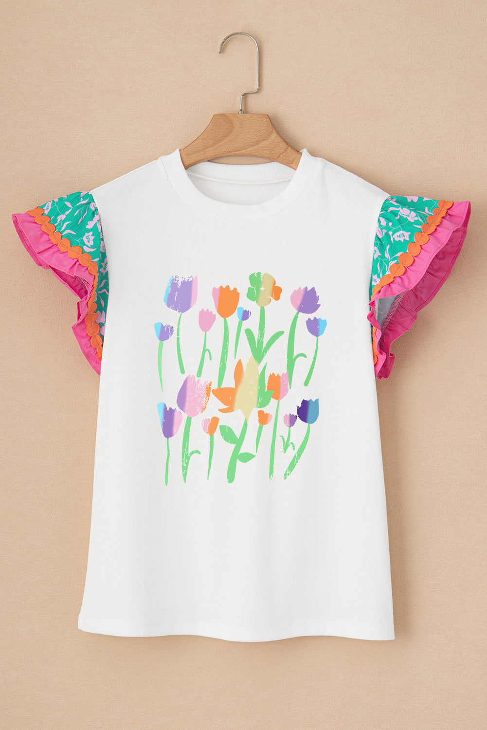 White t-shirt with colorful floral print and ruffled sleeves.