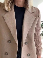 Tan double-breasted trench coat with knit sleeves and button closure.