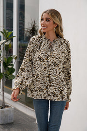 Animal print blouse with ruffle neckline and tie detail, long sleeves.