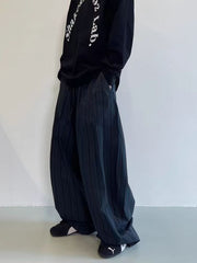 Men's black wide leg sweatpants with vertical pleats and pockets.