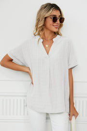 Gathered back v-neck linen blouse in white with subtle plaid texture.