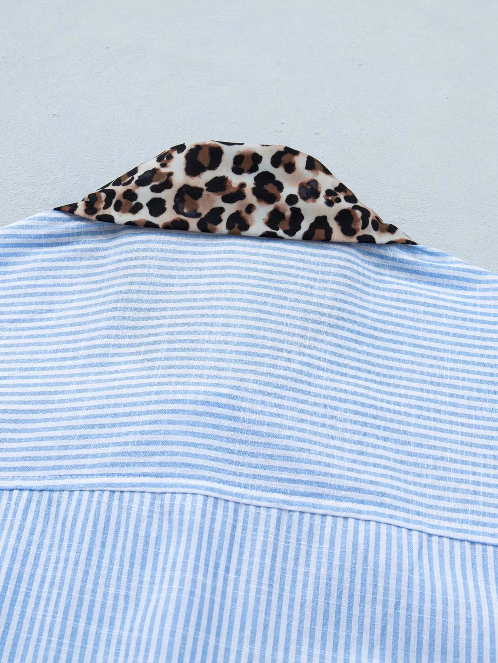 Blue striped button-down shirt with leopard print collar detail