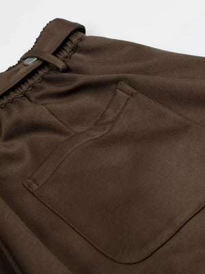 Brown maternity capris with wide legs, pleated detail, elastic waistband, and button closure.