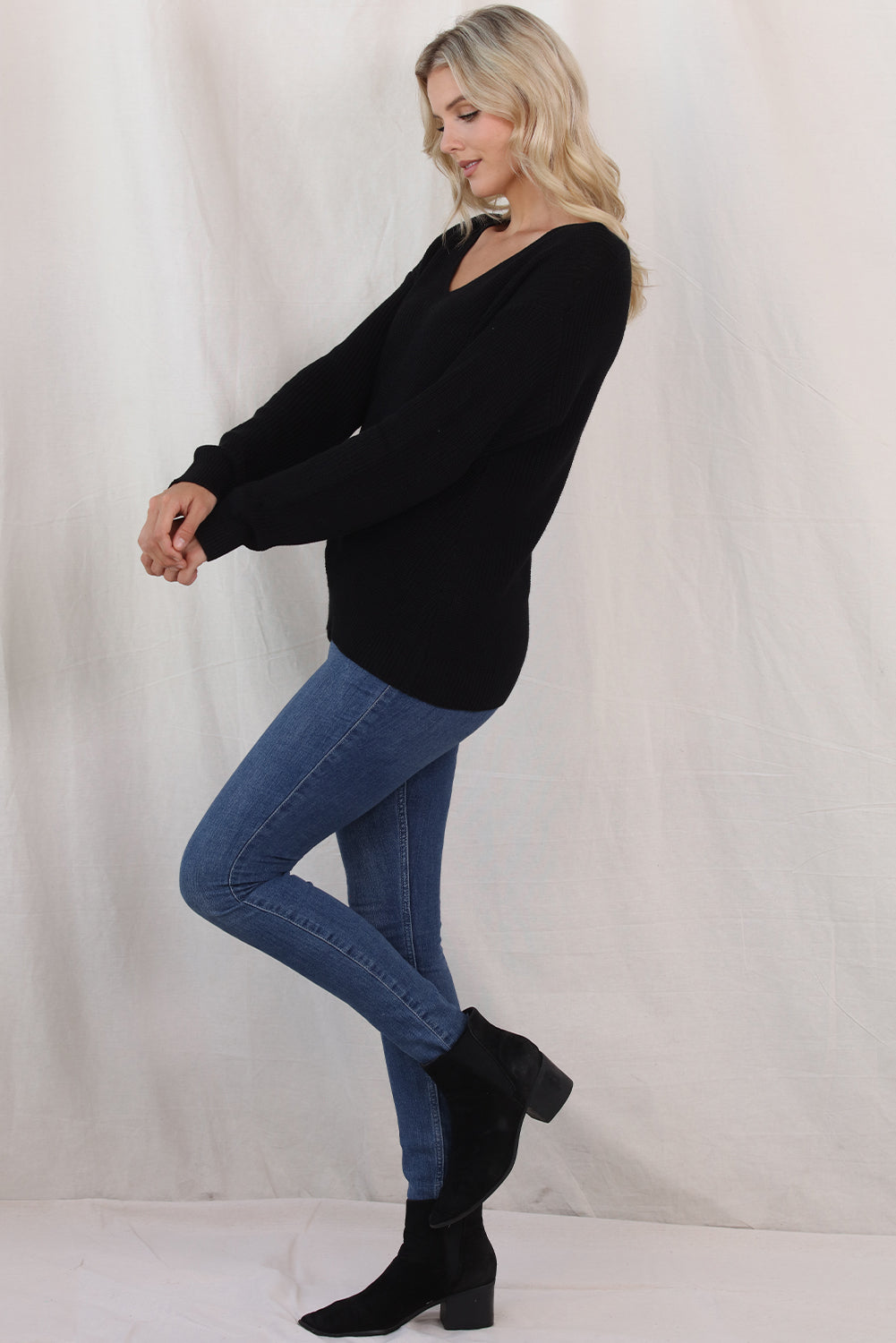 Black relaxed knit V-neck pullover sweater with long sleeves.