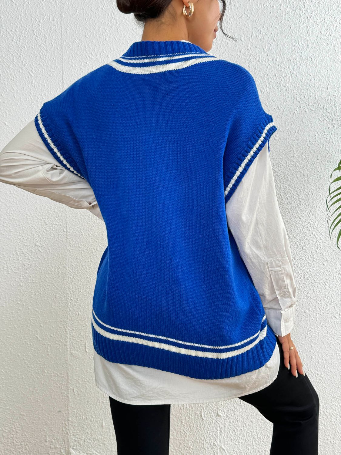 Blue acrylic knit vest with white contrast trim, V-neck, sleeveless, casual style.