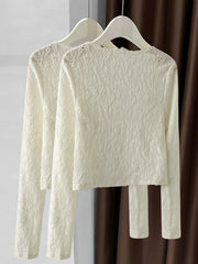 Lace button-up cardigan in cream with delicate textured pattern and long sleeves.