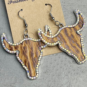 Crystal-trimmed bull skull earrings in caramel with wood grain texture and rhinestone accents.