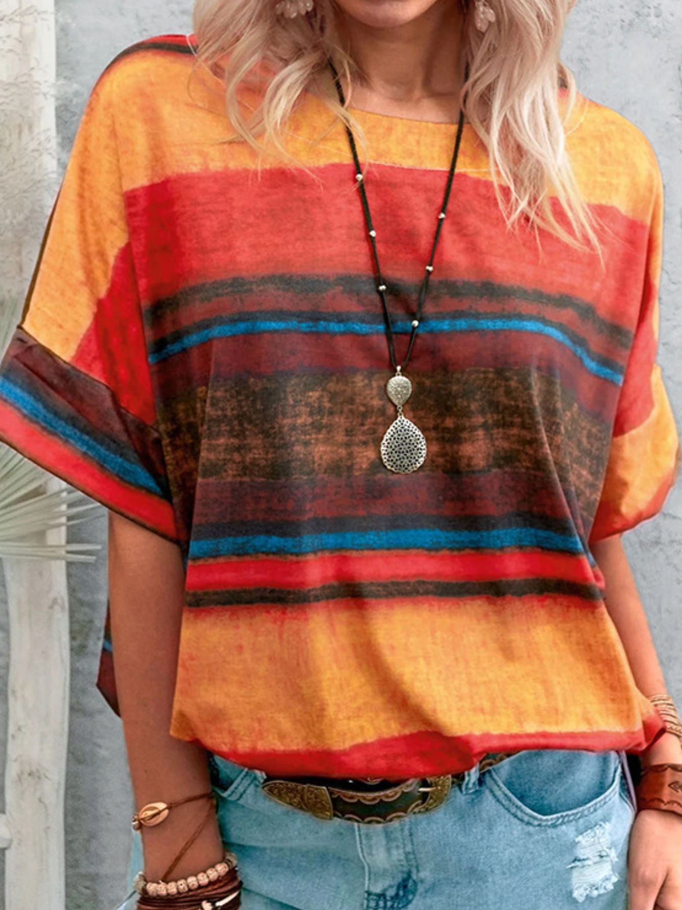 Casual t-shirt with brushstroke stripes in orange, red, blue, and brown.