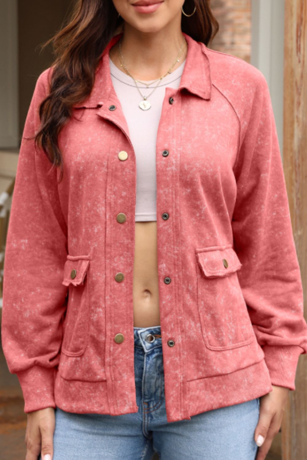 Washed cotton utility jacket in burnt coral with snap front, chest pockets, and button cuffs.