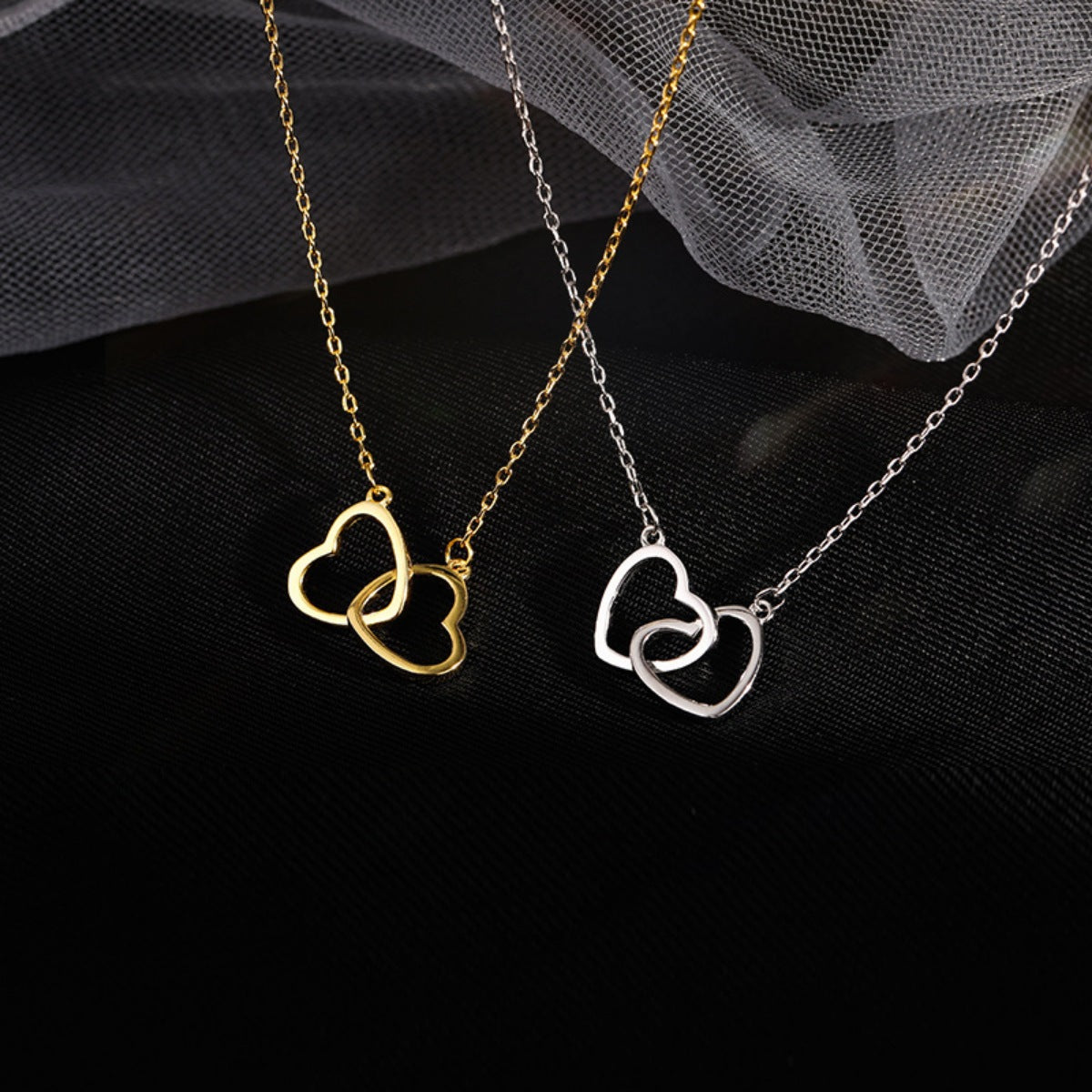 Interlocking heart pendant necklaces in gold and silver, delicate jewelry for women.