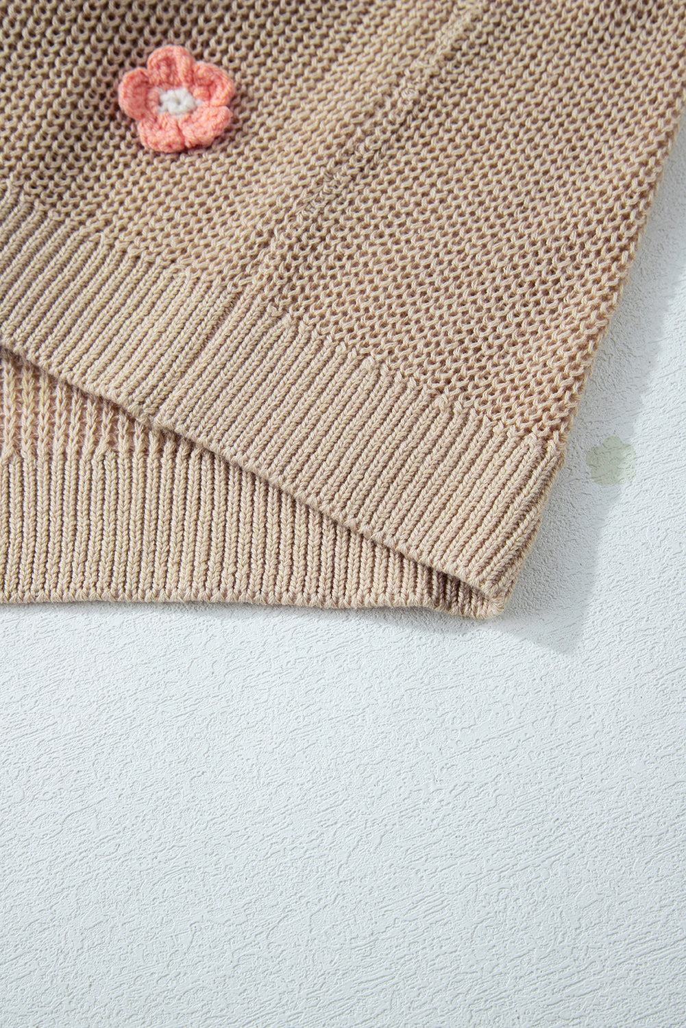 Khaki knit sweater with embroidered floral detail and ribbed trim.