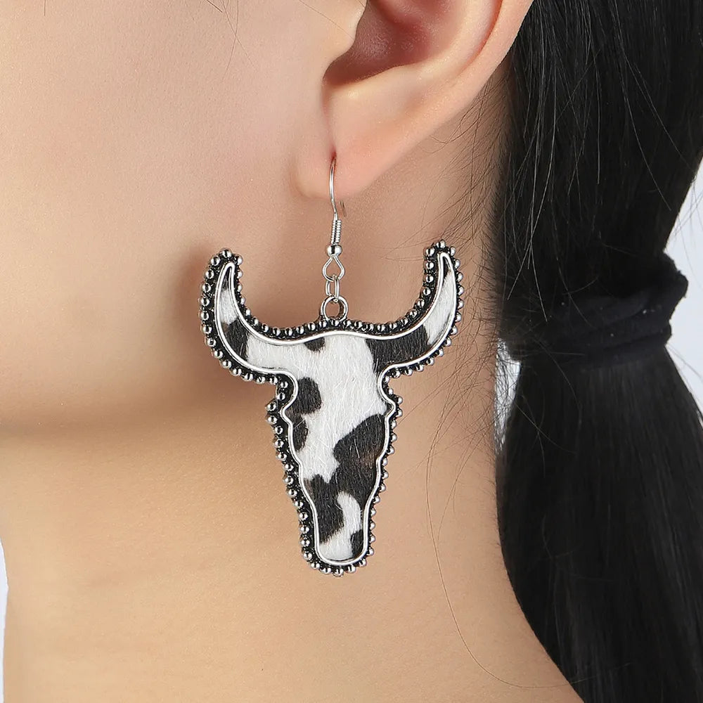 Cow print bull head drop earrings with beaded silver-tone trim.