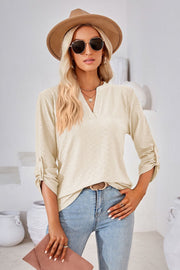 Ivory textured henley blouse with rolled sleeves and V-neck.