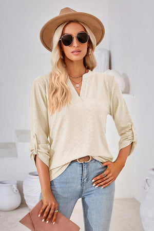 Ivory textured henley blouse with rolled sleeves and V-neck.