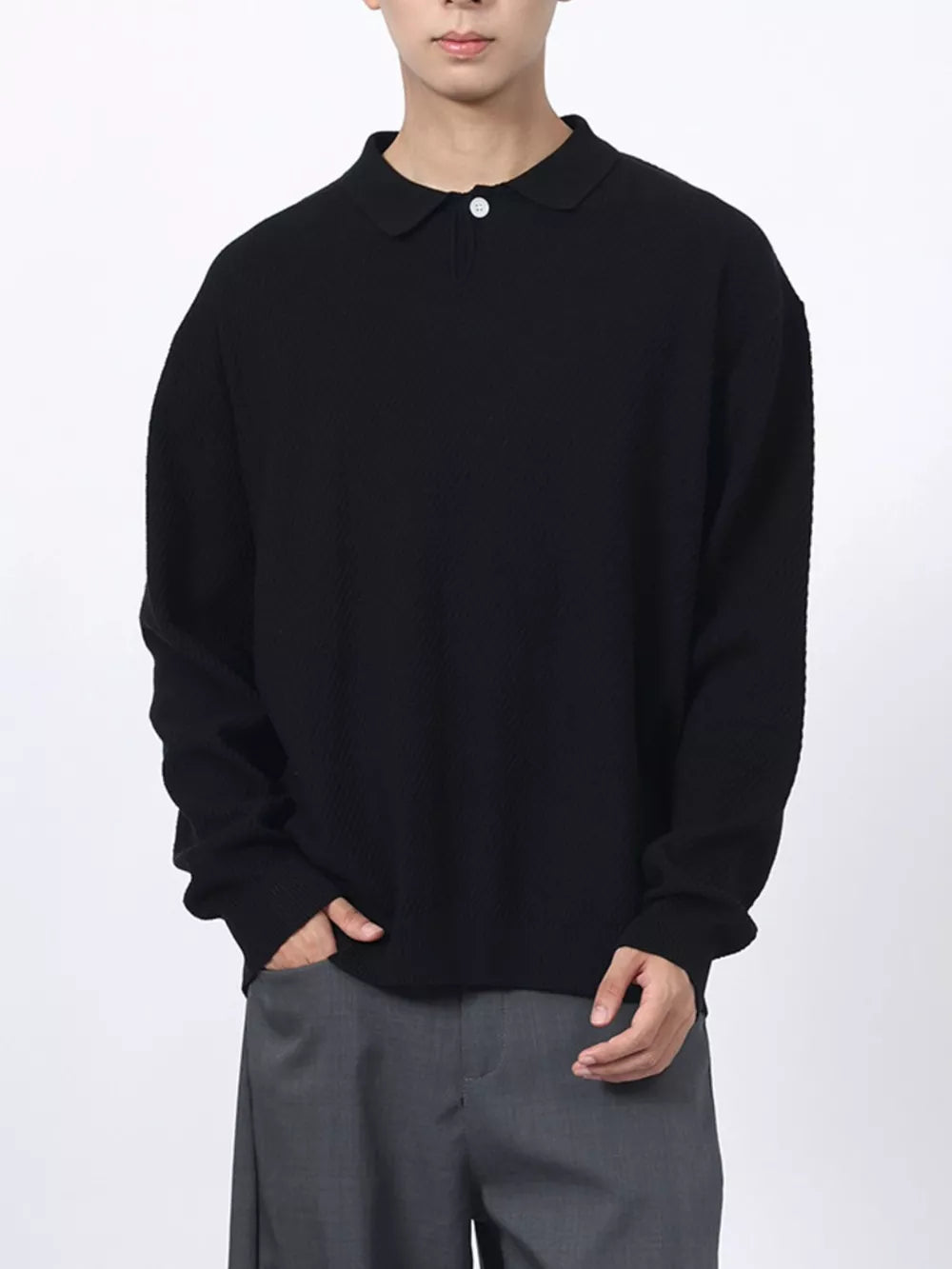 Men's black textured knit polo shirt with a classic collar and button closure.