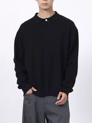 Men's black textured knit polo shirt with a classic collar and button closure.