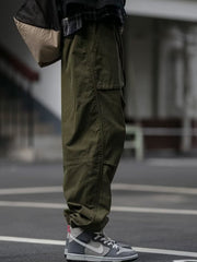 Men's army green drawstring sweatpants with multiple pockets and a relaxed fit.