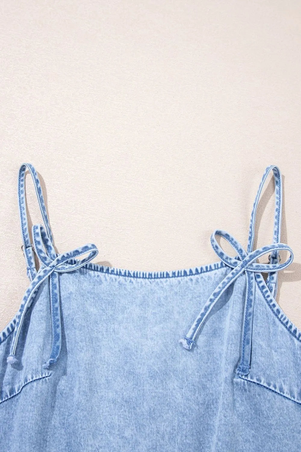 Light blue denim sundress with tie shoulder straps and ruffled hem detail.