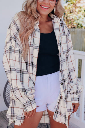Oversized white plaid shacket with button front and cuffed sleeves, layered over a black tank top.