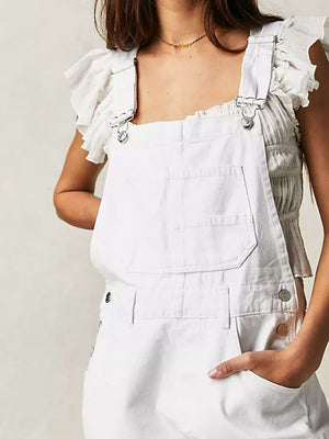 White denim short overalls with square neck and ruffled sleeves, styled with a smocked top.