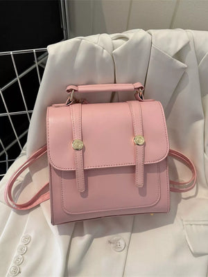 Chic blush pink PU leather mini backpack with gold buckle details and top handle.