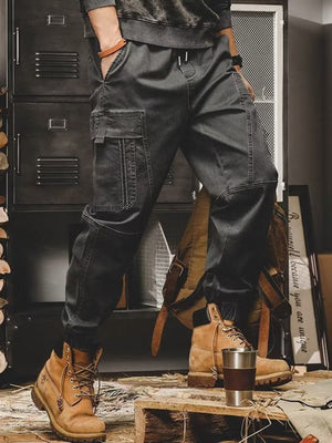 Men's black relaxed fit cargo pants with multiple pockets and elastic cuffs.