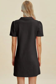 Black textured mini dress with short sleeves and a collared V-neck, shown from the back.