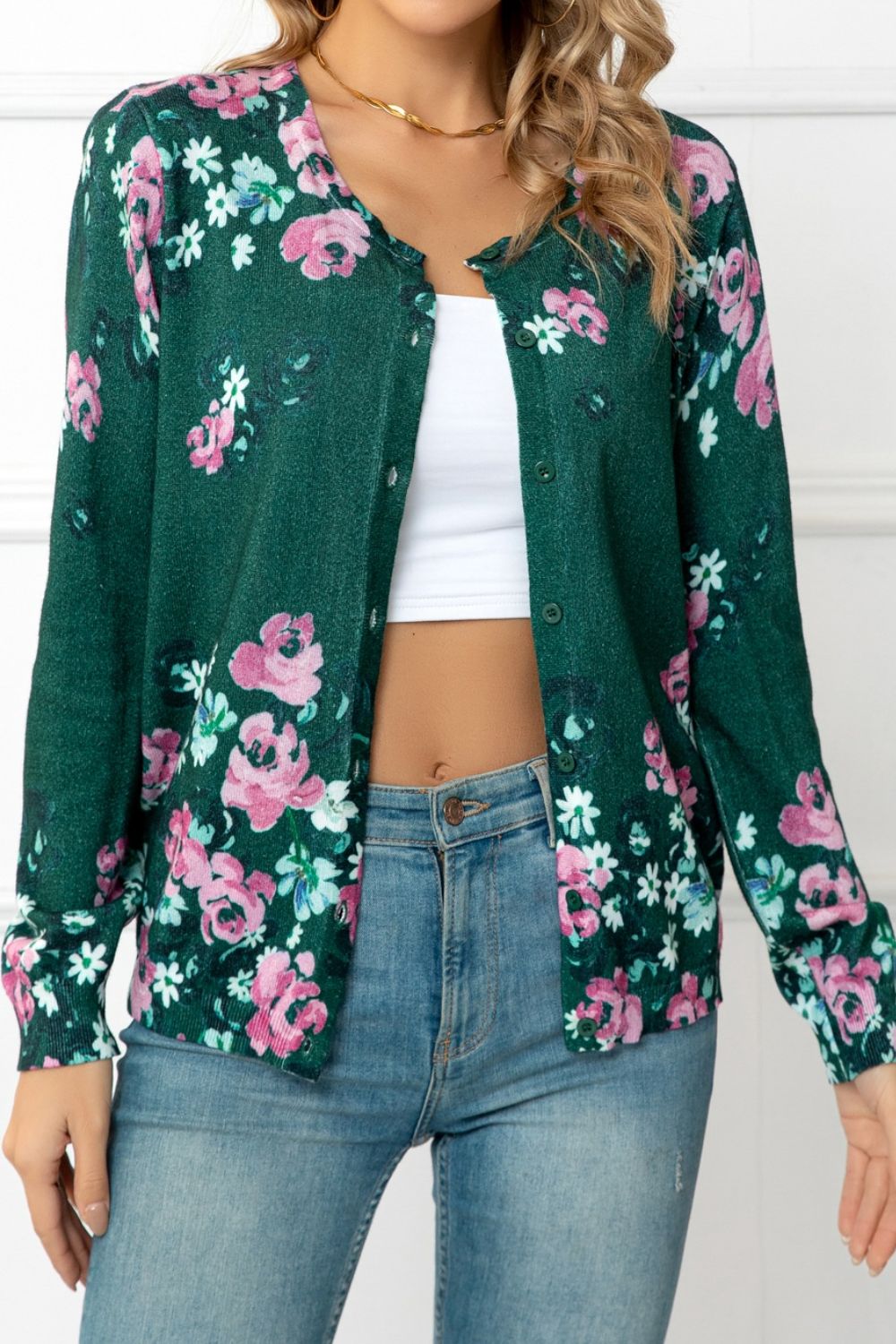 Forest green crewneck cardigan with a pink and white botanical floral print, button front.