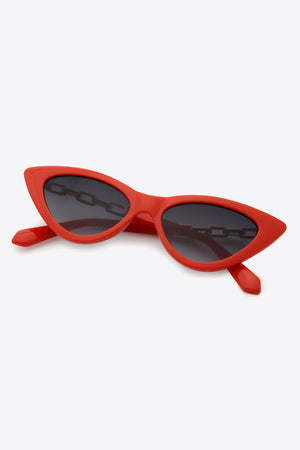 Chainlink cat-eye sunglasses in deep red with a chain detail across the lenses.