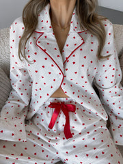White cotton pajama set with red heart pattern and red trim, button front top and drawstring shorts.