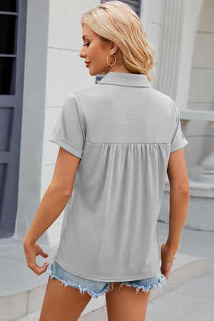 Light gray short sleeve polo top with gathered yoke detail and cuffed sleeves.