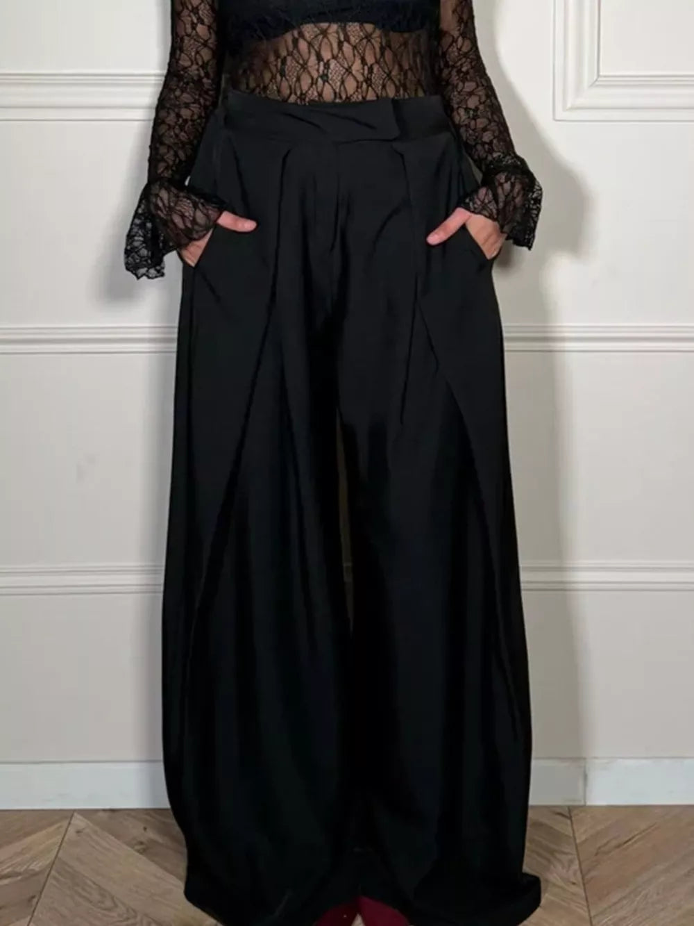 Black wide-leg pants with pockets, styled with a lace top.
