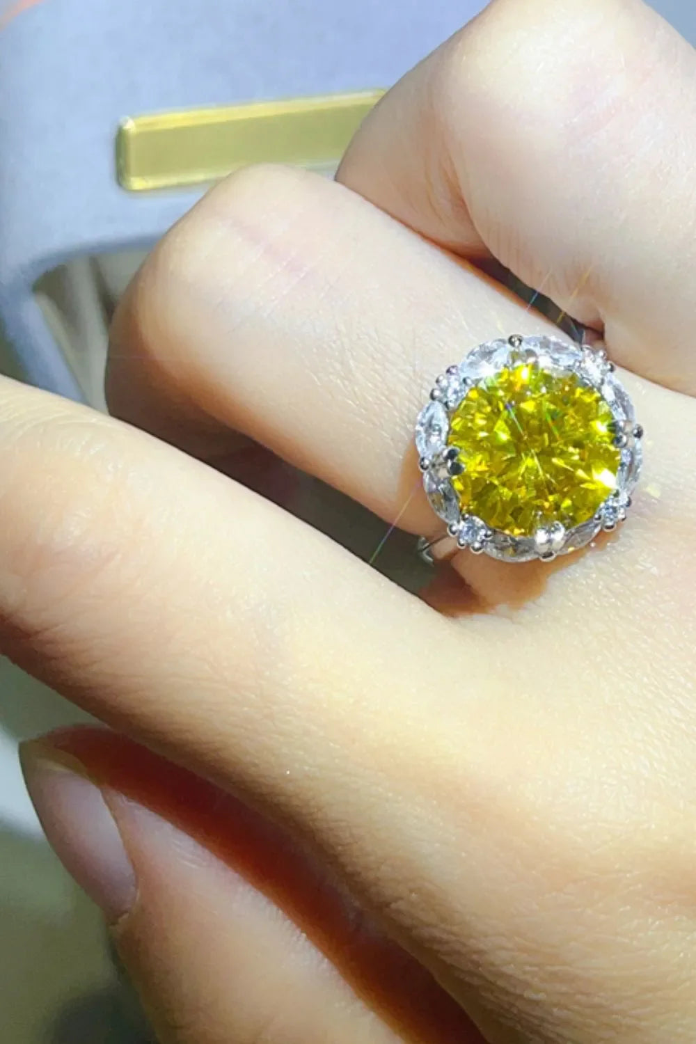 Radiant Halo Yellow Gemstone Ring with clear accent stones on a silver band.