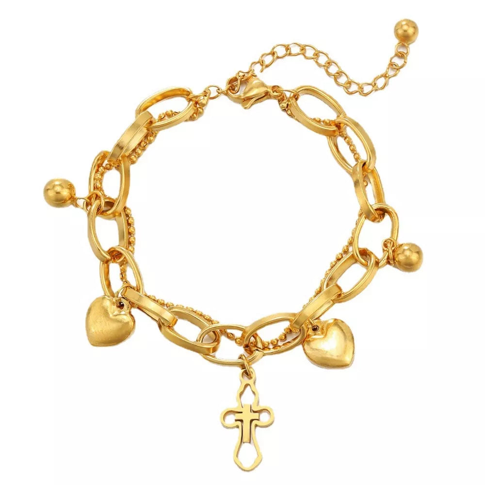 Gold tone charm bracelet with hearts, balls and a cross charm.