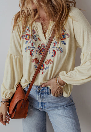 Pastel yellow embroidered poet sleeve blouse with colorful floral detail and v-neck