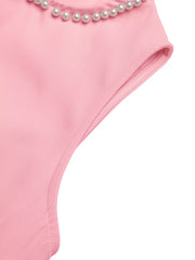 Pink mini dress with pearl trim detail at the neckline and cap sleeves.