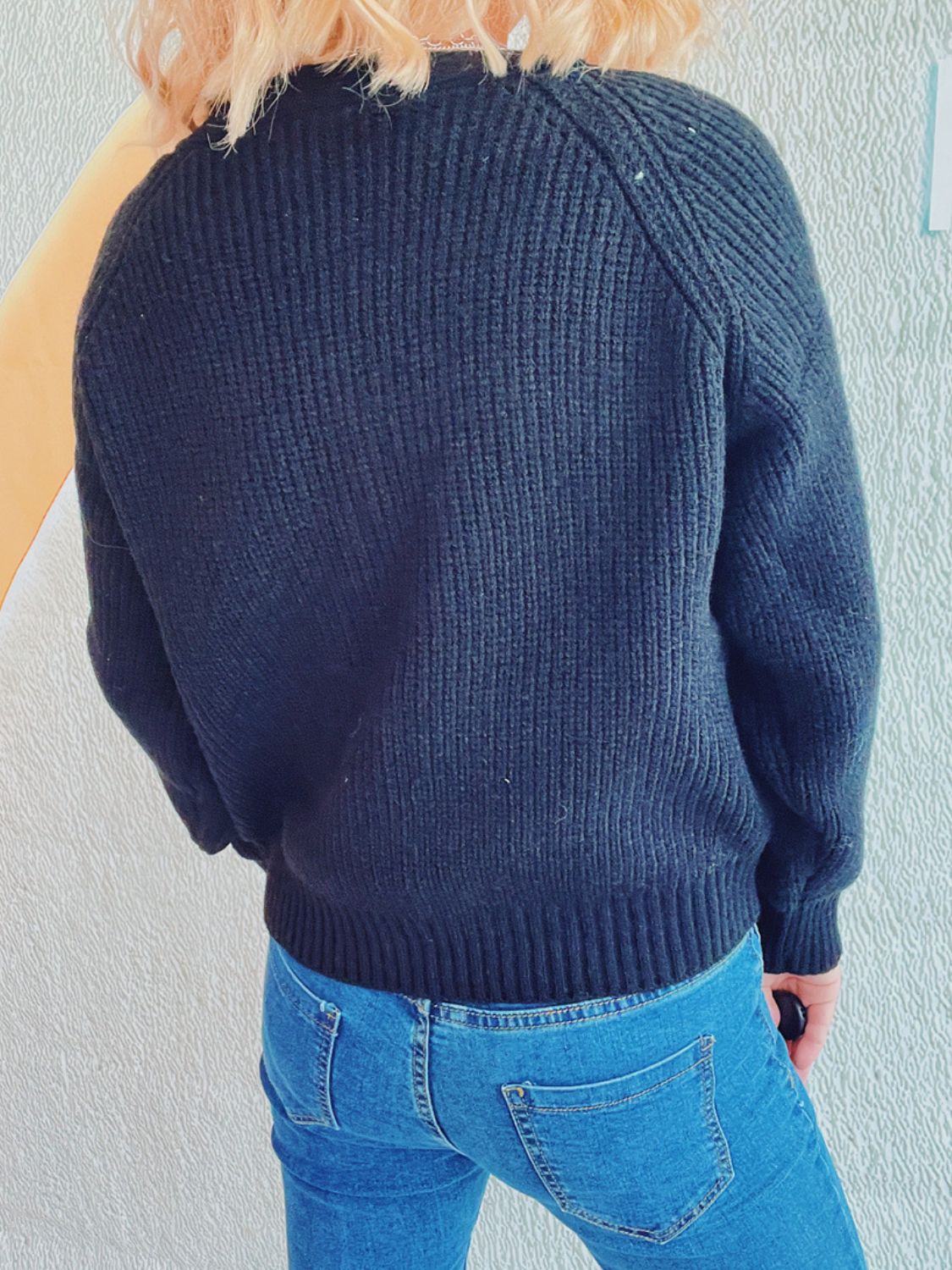 Black cable knit raglan cardigan with ribbed cuffs and hem.