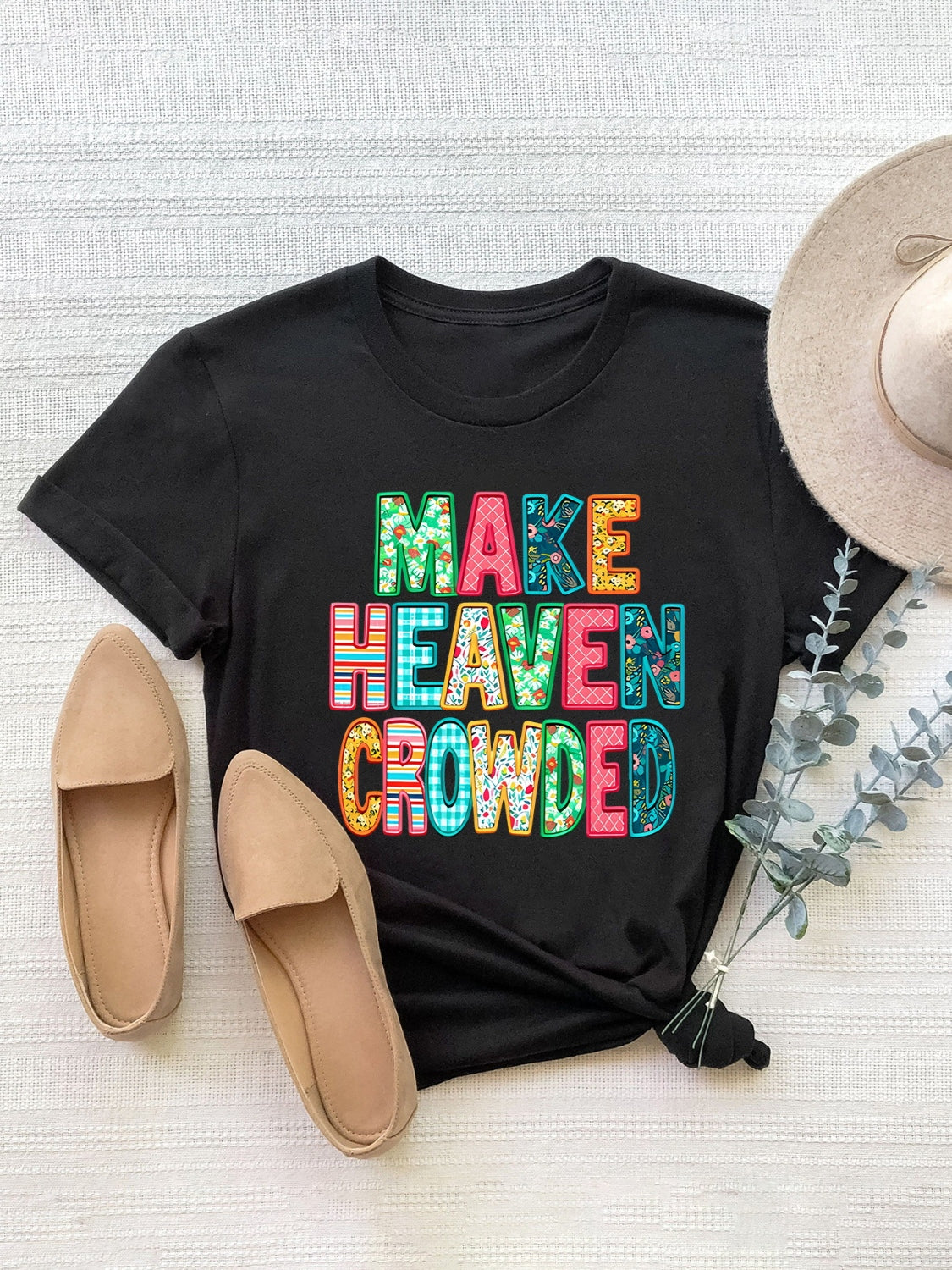 Black t-shirt with textured lettering that says MAKE HEAVEN CROWDED in colorful patterns.