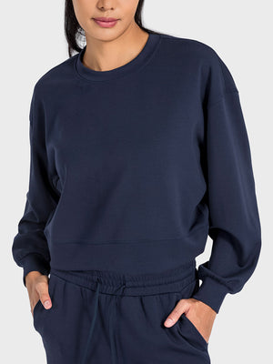 Dark blue cropped crewneck sweatshirt with gathered sleeves and crew neckline.