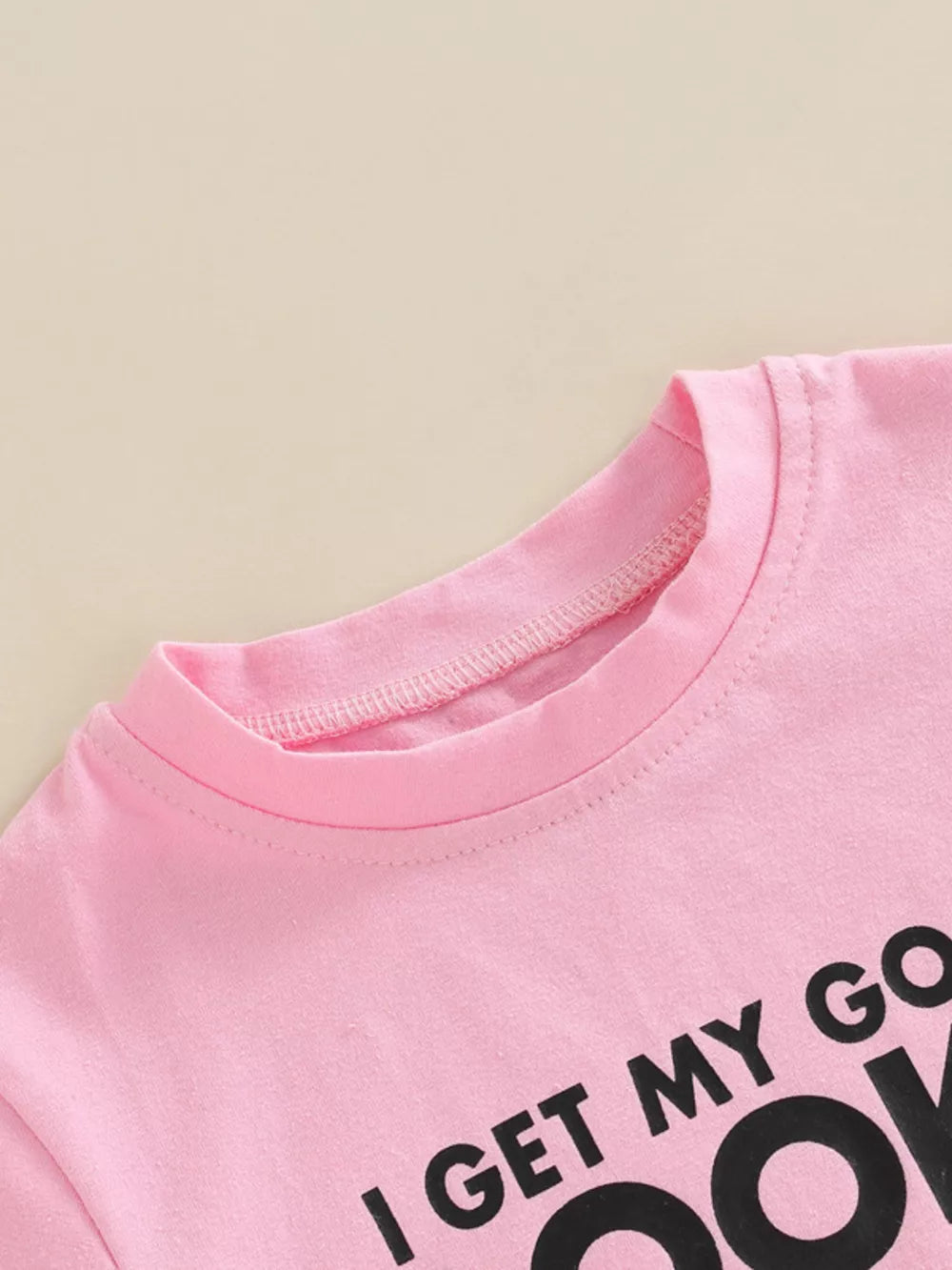 Pink cotton tee with black lettering detail, crew neck, short sleeves.