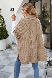 Camel cable knit turtleneck poncho with side slit and textured knit.