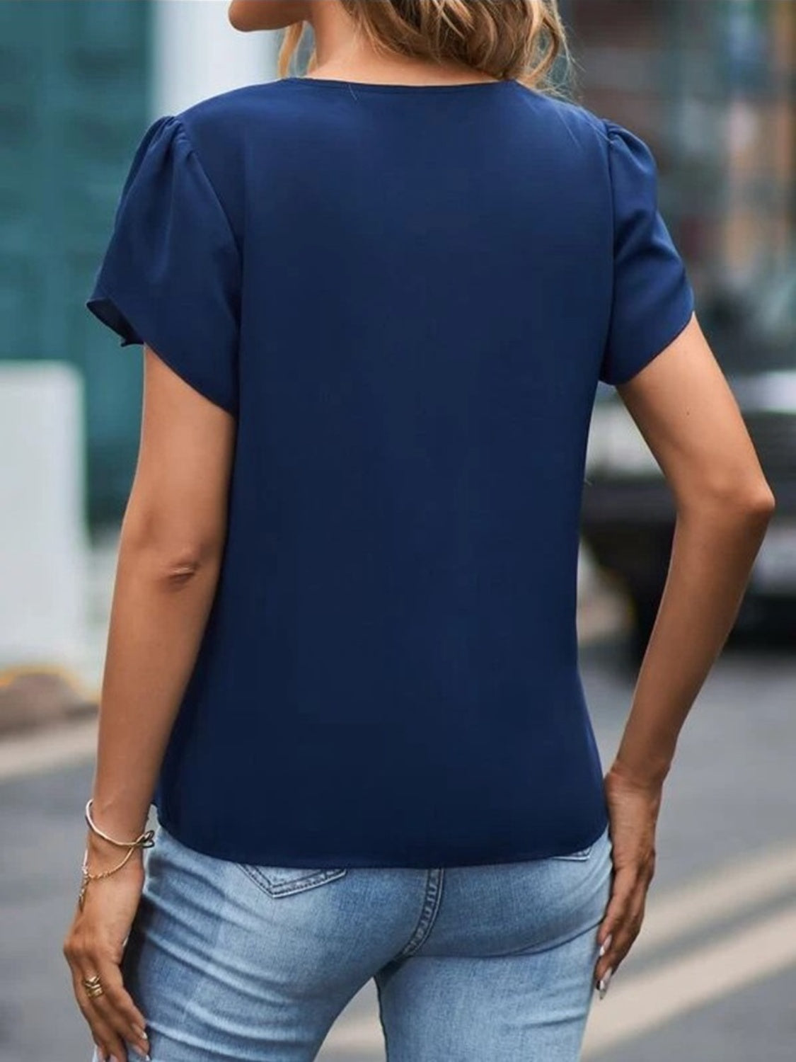 Dark blue lace trim flutter sleeve blouse with a round neckline.