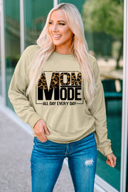Khaki sweatshirt with leopard print "MOM MODE" graphic and long sleeves.