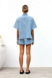 Relaxed light wash denim shirt and drawstring shorts set with short sleeves and a collared neckline.