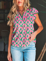 Abstract heart print polo blouse with green trim and flutter sleeves, pink and green ikat pattern.
