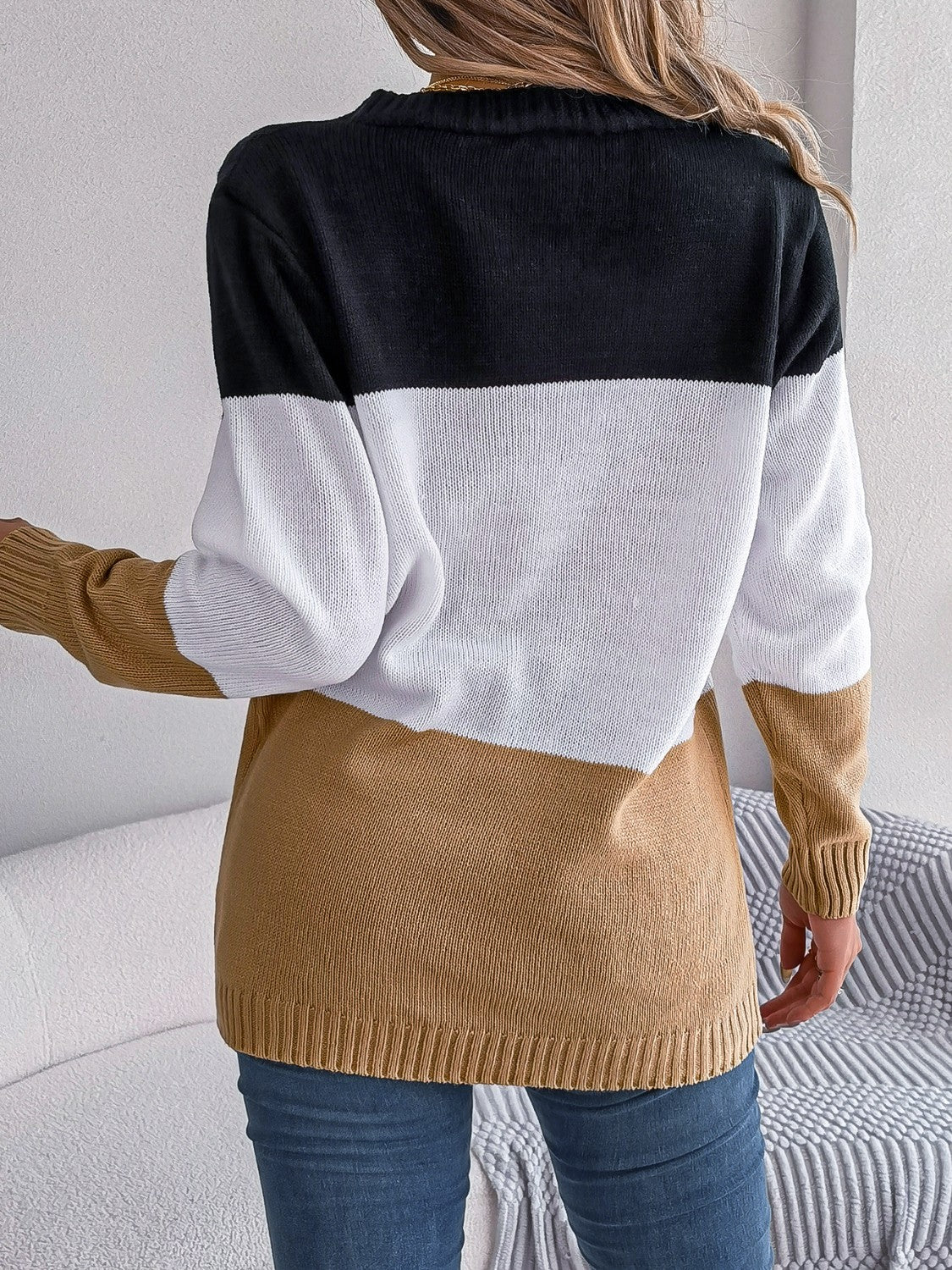 Colorblock cable knit cardigan in camel, white, and black acrylic with ribbed cuffs and hem.
